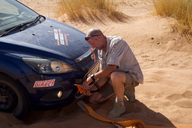 Preparing to tow one of the cars from deep sand